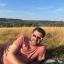 Me lounging on a picnic blanket in a field, wearing eclipse glasses
